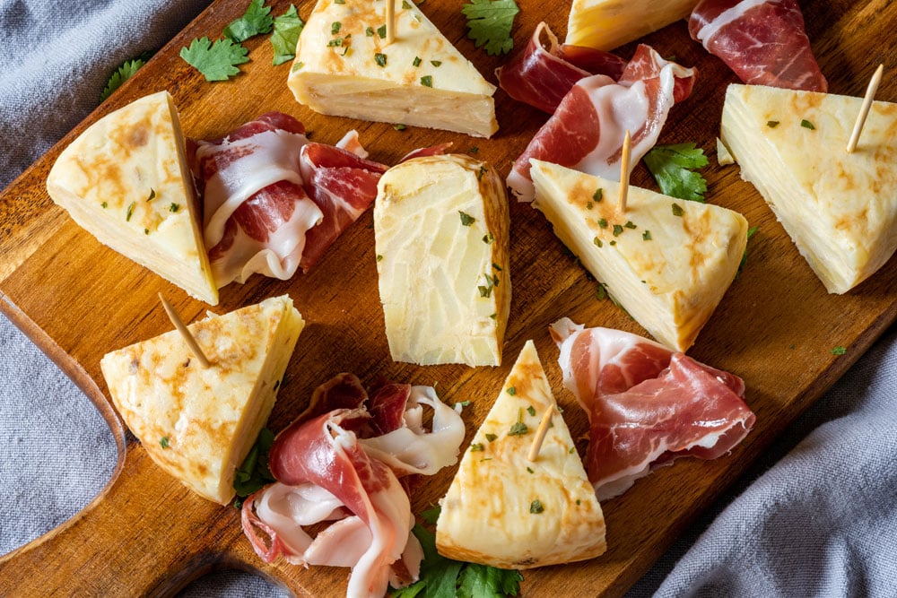 Plate with sliced tortilla espanola and Spanish ham