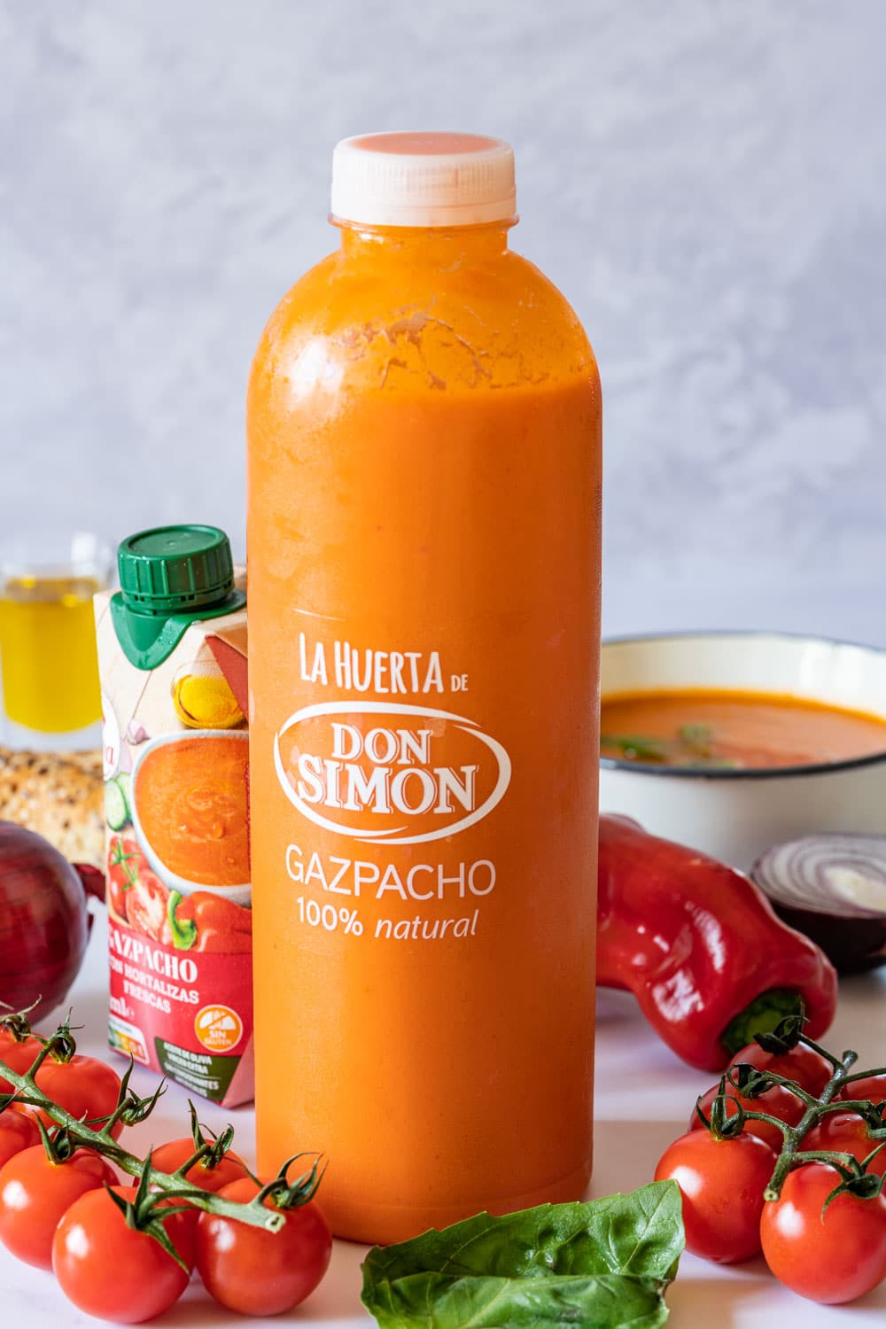 Bottle of gazpacho with fresh tomatoes