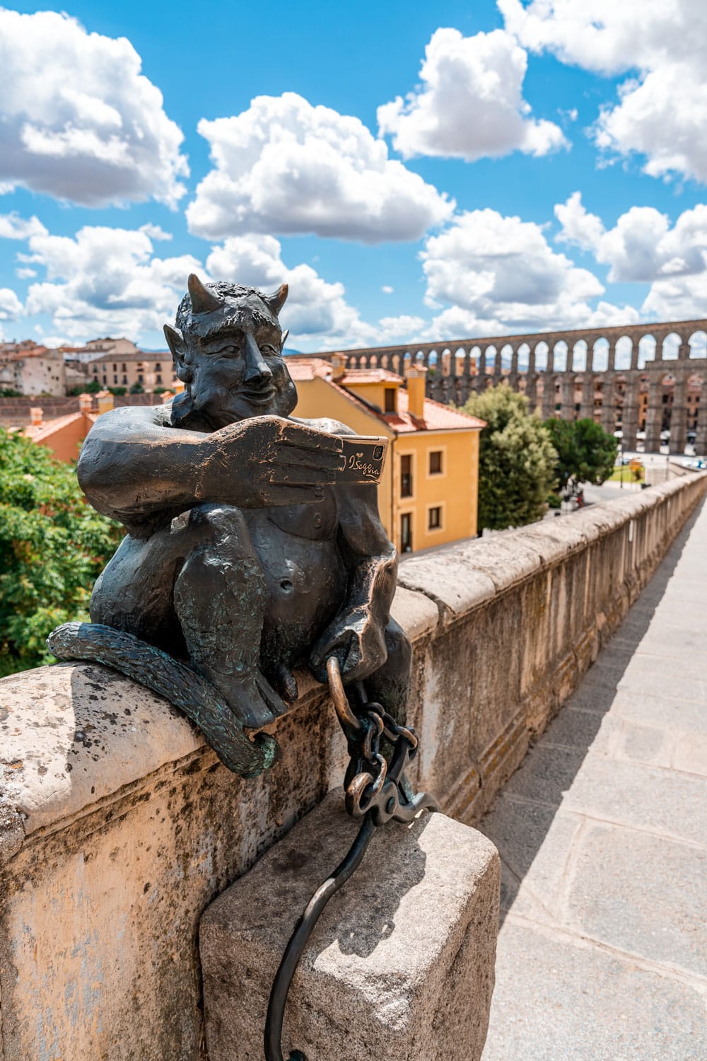 Segovia in a Day - Statue of Devil taking selfie near the Aqueduct