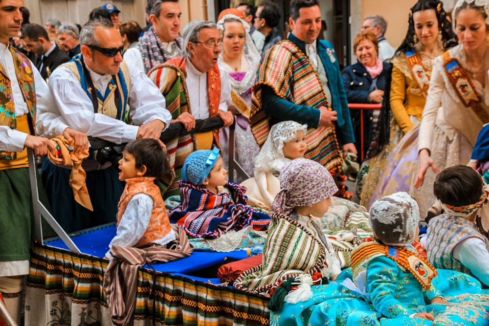 Parents pushing their kids at the Las Fallas Festival parade