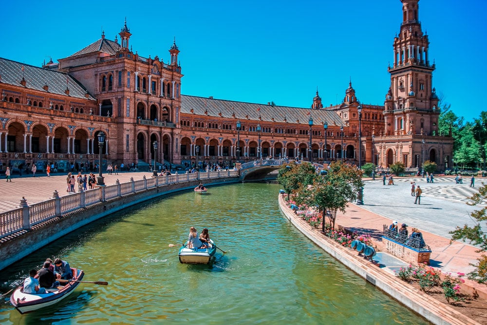 Boats with tourists on a canal surrounding the Plaza de Espana, Seville, Andalusia