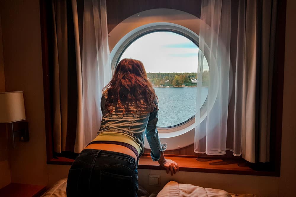 The woman looks out of the cabin window at Gulf of Finland