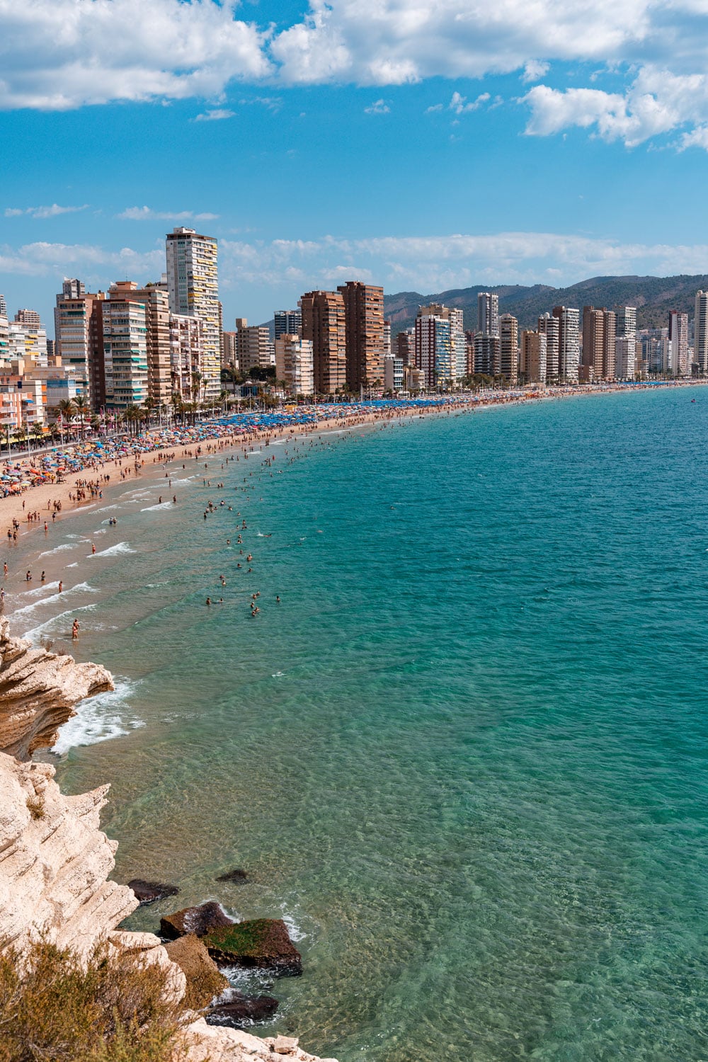 Long sandy beach in Benidorm with high buildings.