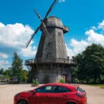 Red Ford Puma and wooden windmill in Europe.