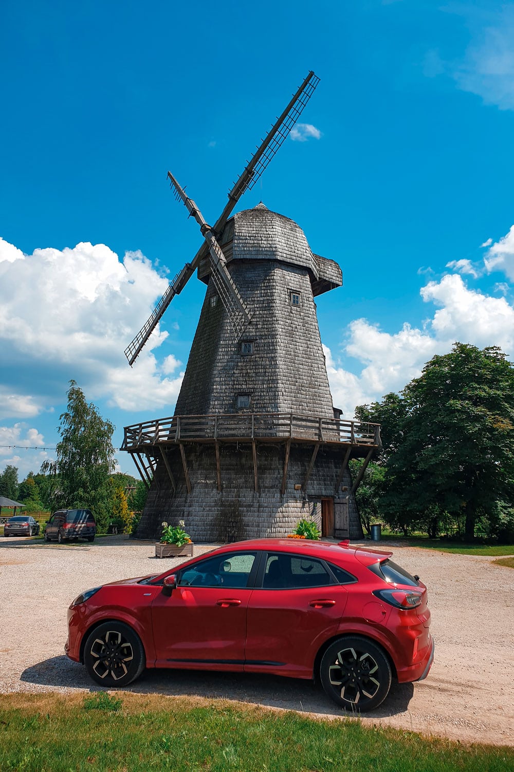 Red Ford Puma and wooden windmill in Europe.