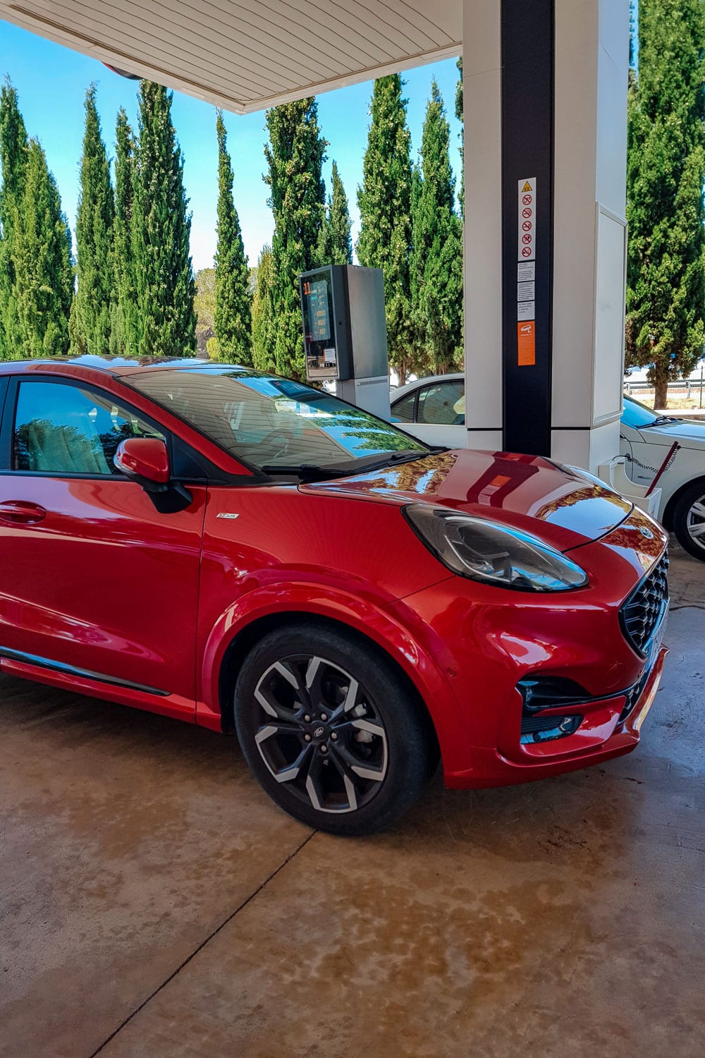 Red car in petrol station.