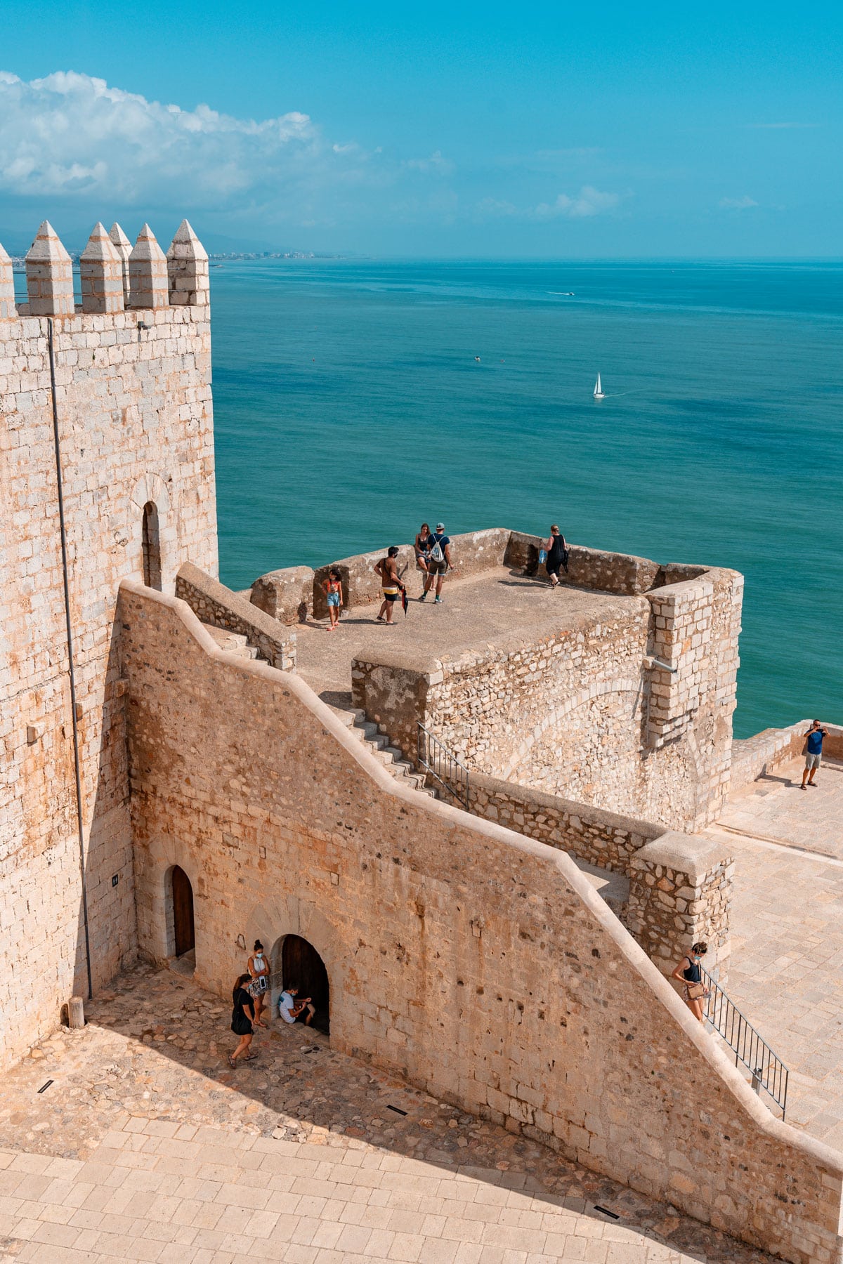 Visitors exploring Peniscola Castle, overlooking the Mediterranean Sea.