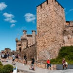 People walking up to Ponferrada Castle entrance.