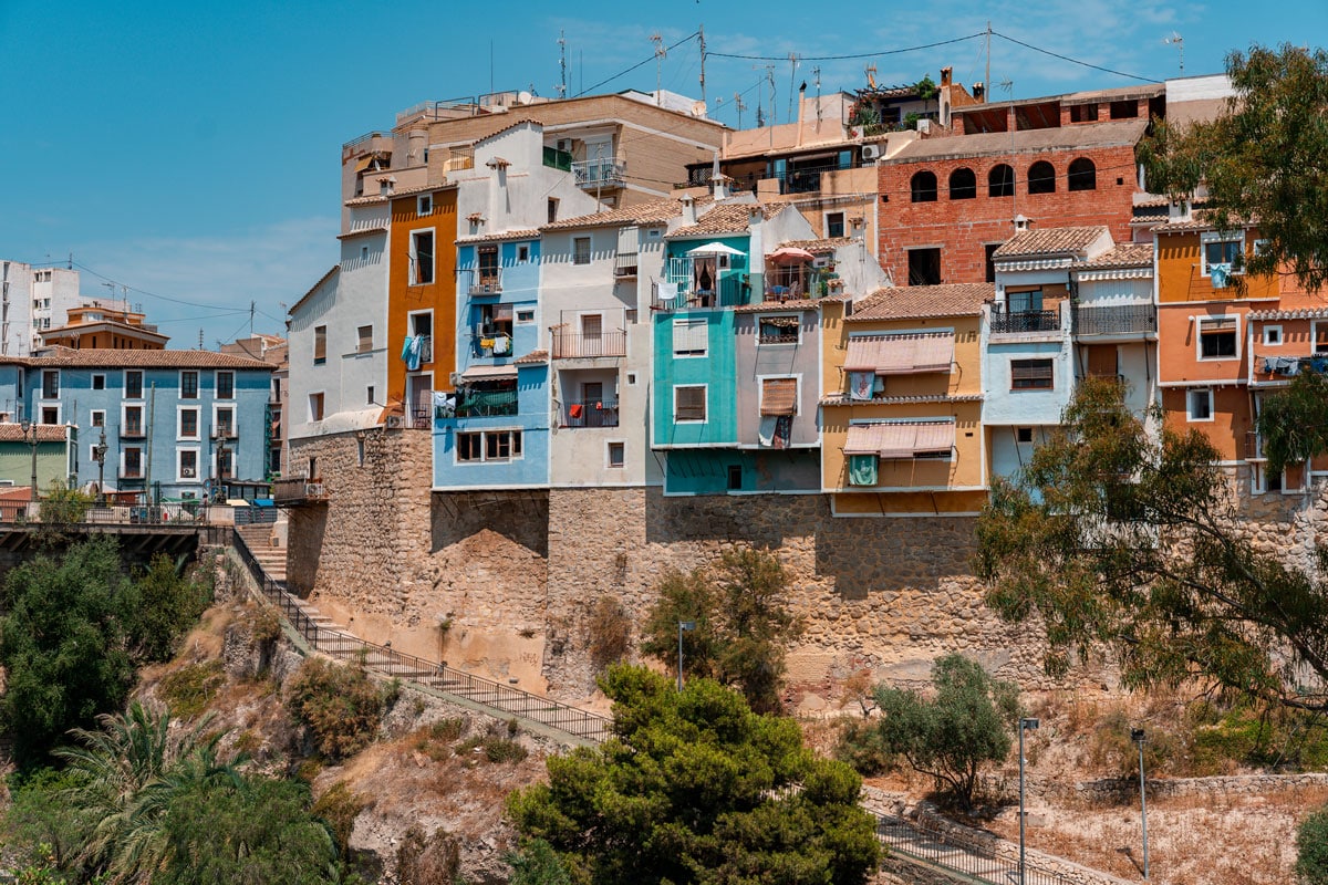 Vibrant Spanish town with colorful buildings under a clear sky.