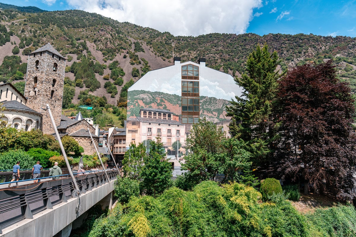 Transparència mural and Sant Esteve Church with mountain backdrop in Andorra la Vella.