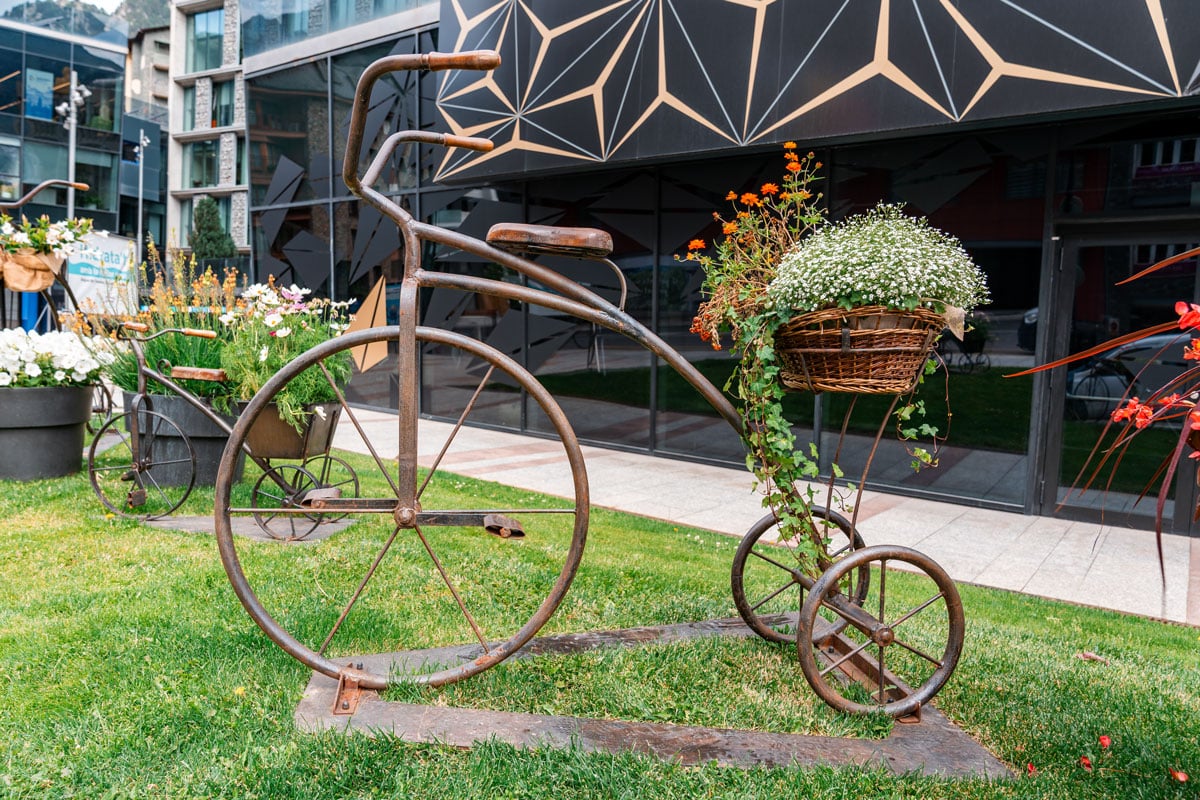 Decorative metal bicycle planter with flowers in the city center.