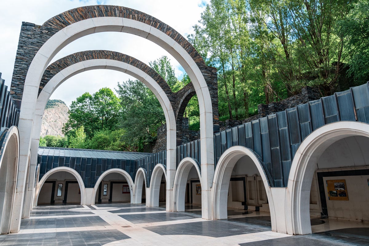 Series of white and dark stone arches at the entrance courtyard of the Sanctuary of Meritxell.