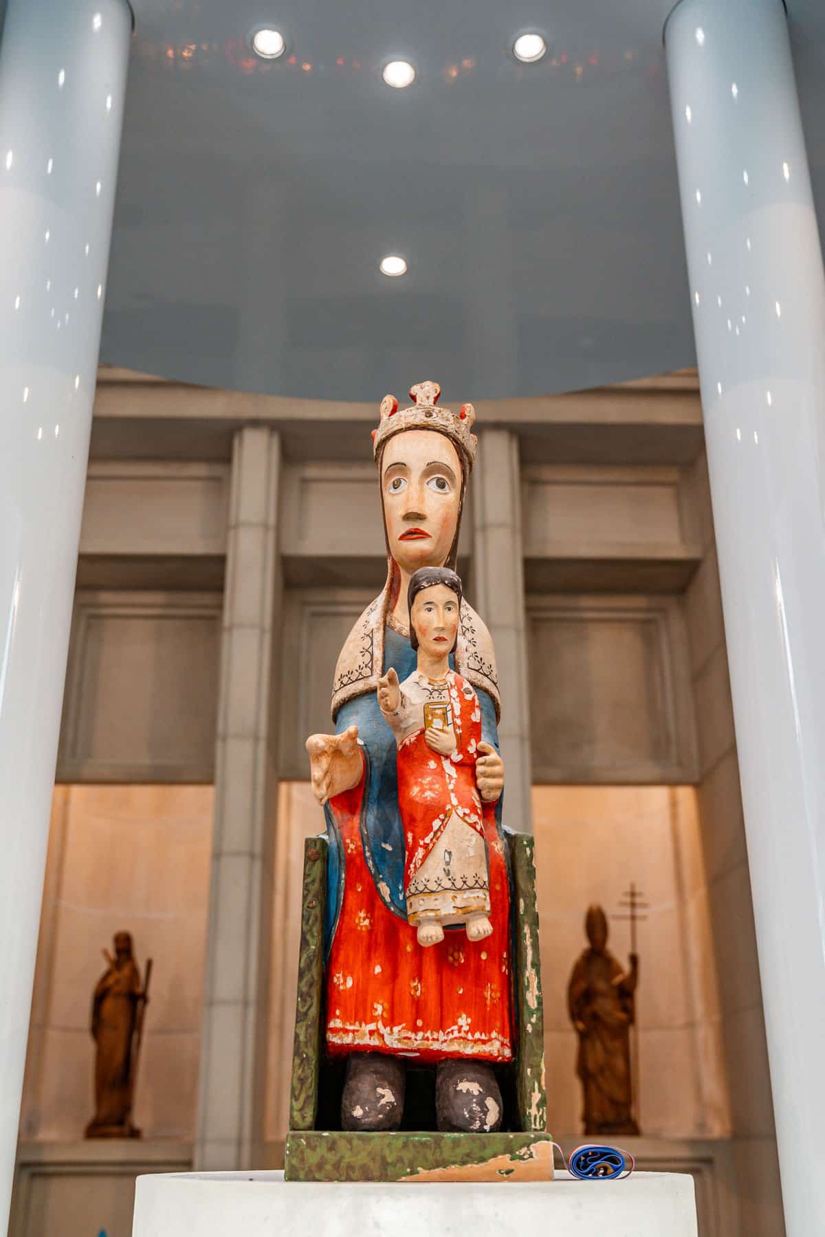 Brightly painted Madonna and Child statue displayed inside the Sanctuary of Meritxell.