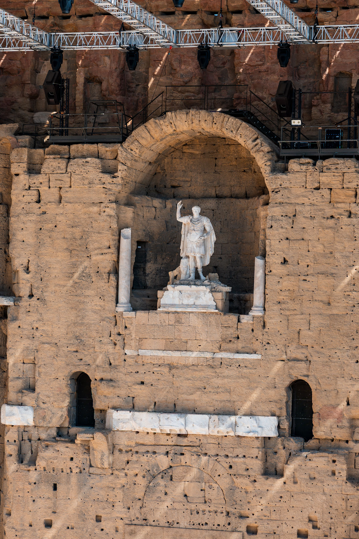 The statue of Augustus standing in a niche high on the stone stage wall.