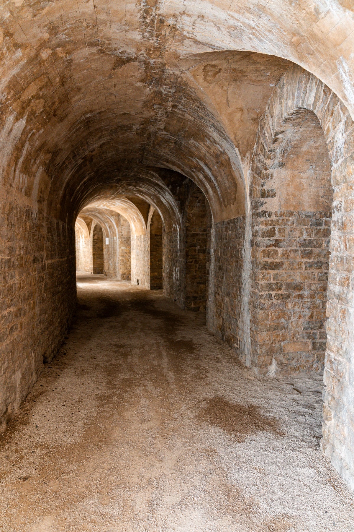 A long vaulted stone corridor beneath the seating.
