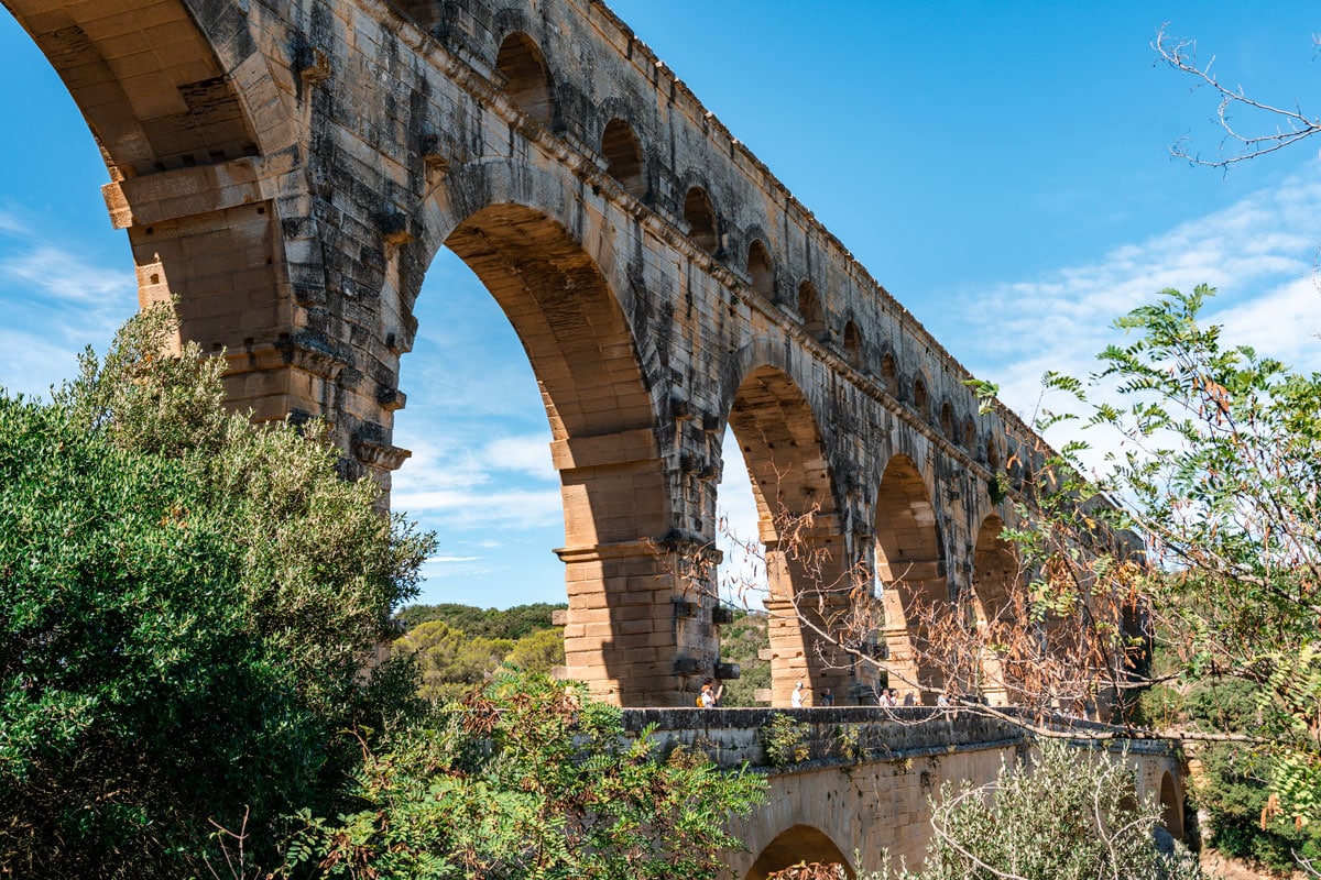 Close side view of the stone arches and pillars of the Pont du Gard aqueduct.