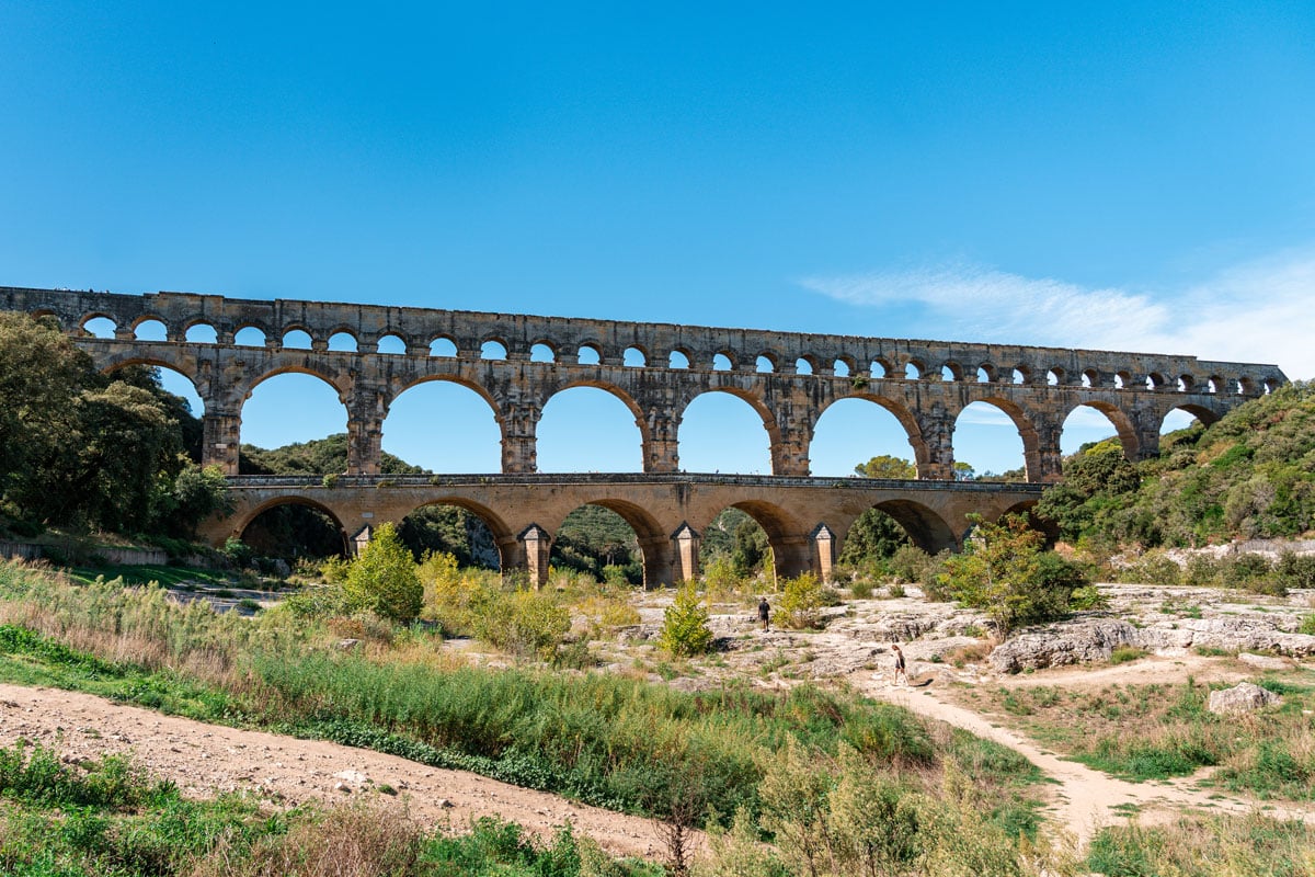 Three tiers of the Pont du Gard aqueduct seen from the path.