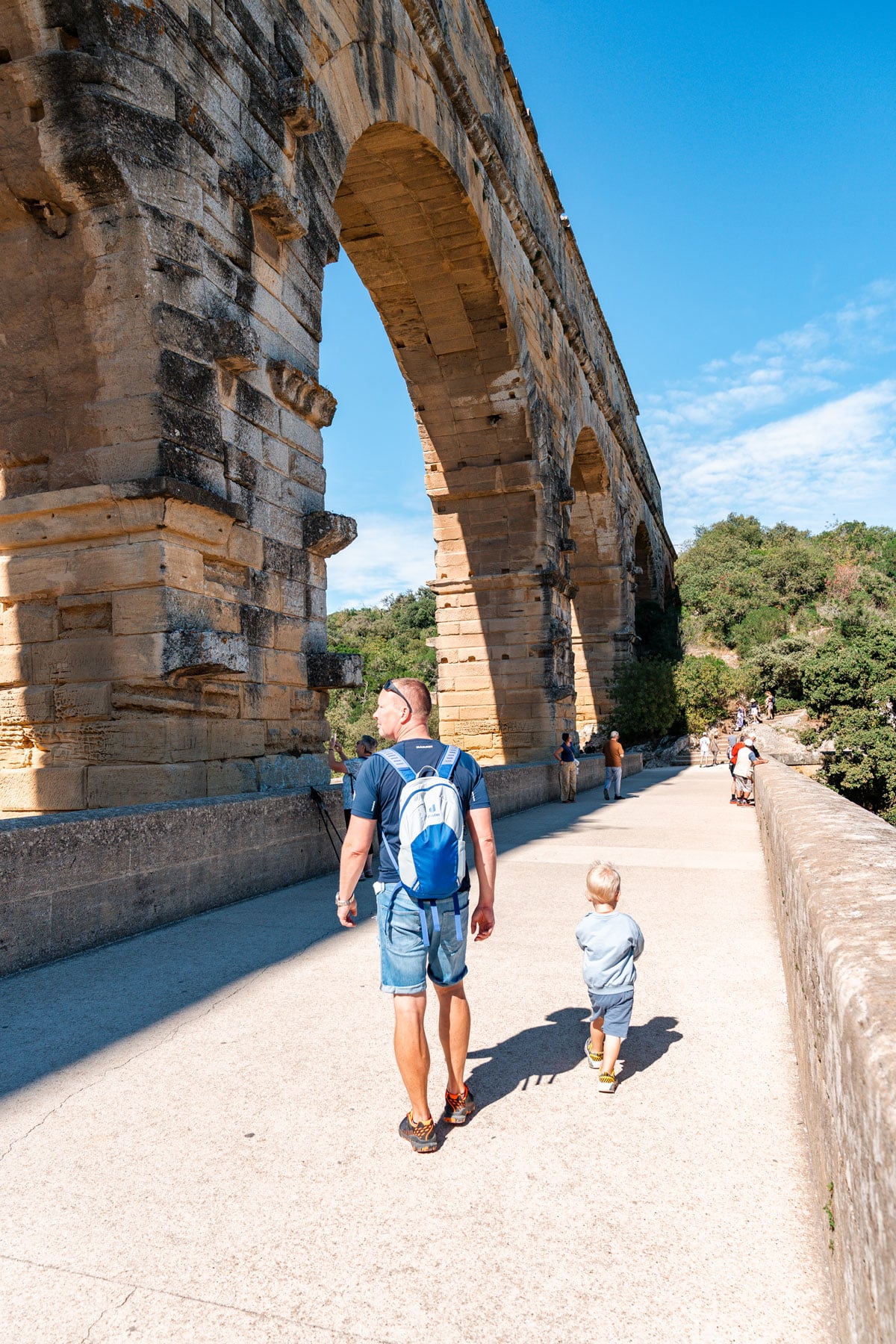 My husband and my little one crossing the lower level of Pont du Gard.